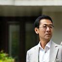 モダンな建築物と融合した庭園を背景にした建築家の男性。